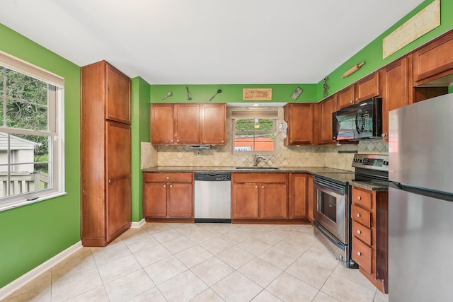316 Westview Ave, Columbus, OH 43214 - kitchen featuring stainless steel appliances, a sink, tasteful backsplash, brown cabinetry, and light tile patterned floors