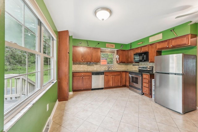 316 Westview Ave, Columbus, OH 43214 - kitchen featuring stainless steel appliances, dark countertops, tasteful backsplash, a sink, and light tile patterned flooring
