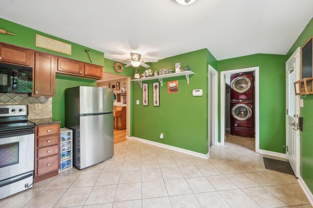 316 Westview Ave, Columbus, OH 43214 - kitchen with stainless steel appliances, stacked washer / drying machine, ceiling fan, brown cabinets, and light tile patterned flooring