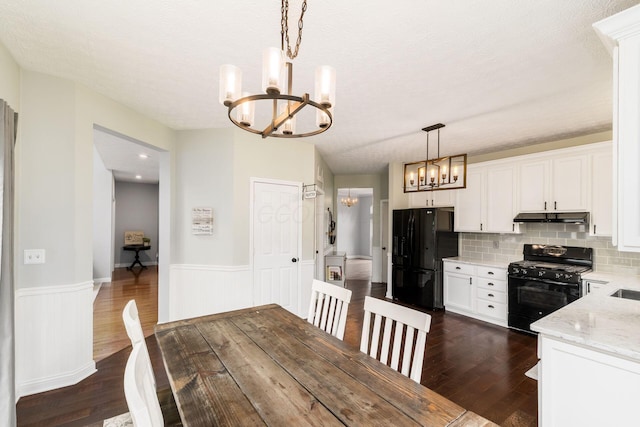 544 Courtright Ct, Pickerington, OH 43147 - dining space featuring a chandelier, dark wood-style flooring, wainscoting, and a textured ceiling