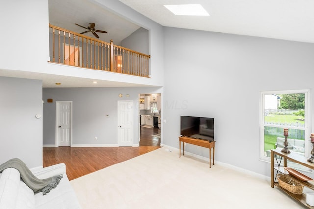 544 Courtright Ct, Pickerington, OH 43147 - living room featuring high vaulted ceiling, a skylight, ceiling fan, baseboards, and wood finished floors