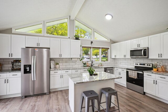 710 Cloverleaf Ct, Mansfield, OH 44904 - kitchen with stainless steel appliances, a sink, light wood-type flooring, tasteful backsplash, and white cabinetry