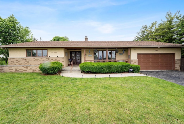 300 Stockbridge Rd, Columbus, OH 43207 - ranch-style home featuring a front yard, a garage, driveway, brick siding, and stucco siding