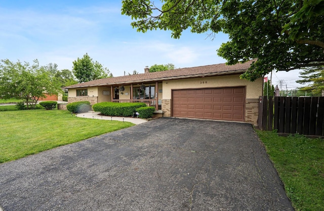 300 Stockbridge Rd, Columbus, OH 43207 - ranch-style house featuring stucco siding, a garage, driveway, covered porch, and stone siding