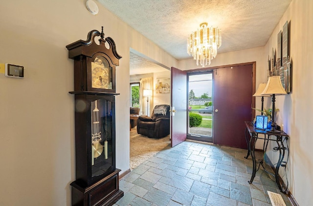 300 Stockbridge Rd, Columbus, OH 43207 - entryway with a textured ceiling, a chandelier, and stone tile floors