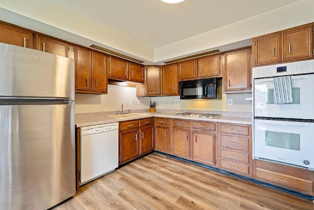 300 Stockbridge Rd, Columbus, OH 43207 - kitchen with appliances with stainless steel finishes, light wood-style floors, light countertops, a sink, and brown cabinetry