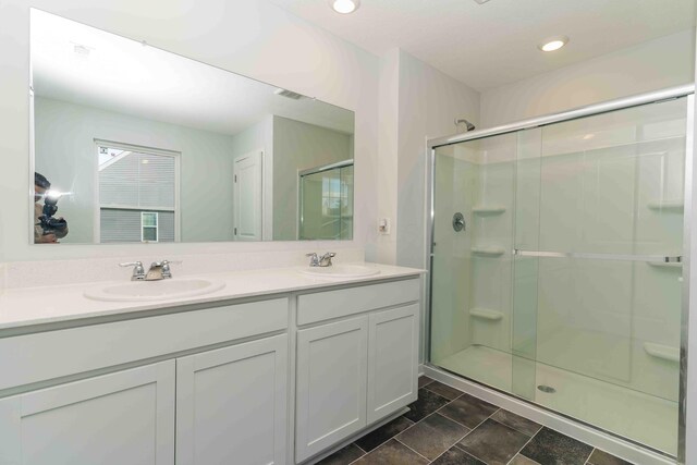 5914 Damsel Dr, Columbus, OH 43232 - bathroom featuring double vanity, a shower stall, recessed lighting, and stone finish floors