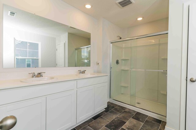 5914 Damsel Dr, Columbus, OH 43232 - full bathroom featuring a stall shower, double vanity, stone finish flooring, and recessed lighting