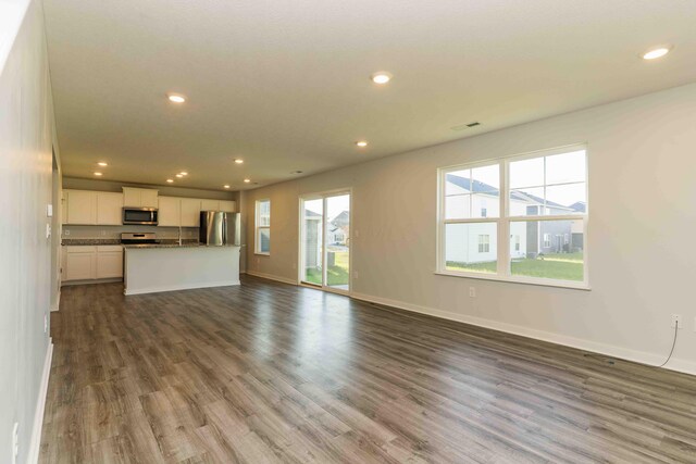 5914 Damsel Dr, Columbus, OH 43232 - unfurnished living room featuring dark wood-type flooring, recessed lighting, and baseboards