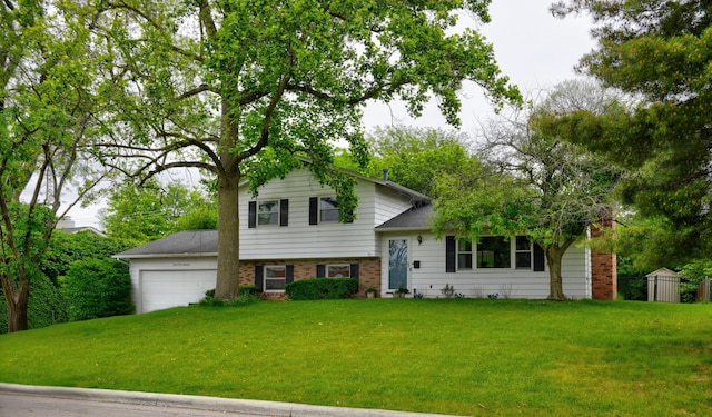 4200 Rudy Rd, Columbus, OH 43214 - tri-level home featuring a front lawn, an attached garage, brick siding, and driveway