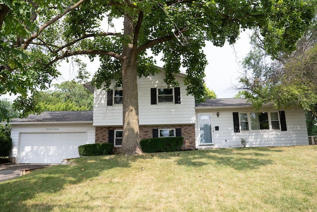 4200 Rudy Rd, Columbus, OH 43214 - split level home with an attached garage, a front lawn, and brick siding