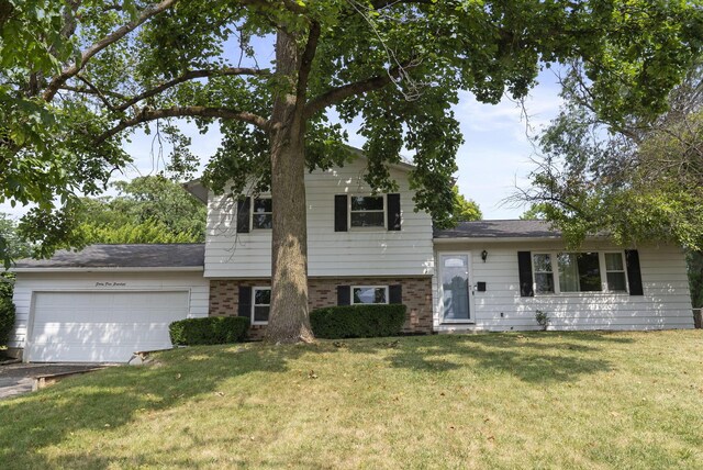 4200 Rudy Rd, Columbus, OH 43214 - split level home with an attached garage, a front lawn, brick siding, and driveway