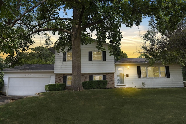 4200 Rudy Rd, Columbus, OH 43214 - split level home featuring a yard, a garage, and brick siding