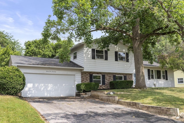 4200 Rudy Rd, Columbus, OH 43214 - split level home featuring driveway, a front lawn, brick siding, and an attached garage