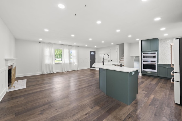 4200 Rudy Rd, Columbus, OH 43214 - kitchen featuring white appliances, light countertops, recessed lighting, a center island with sink, and dark wood-style floors