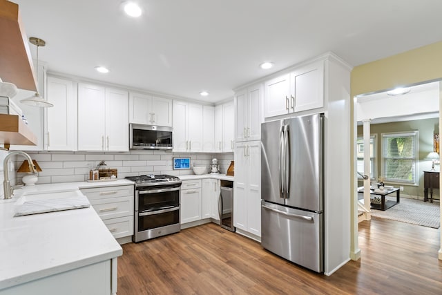 2194 Worthingwoods Blvd, Powell, OH 43065 - kitchen featuring appliances with stainless steel finishes, a sink, dark wood finished floors, tasteful backsplash, and white cabinets