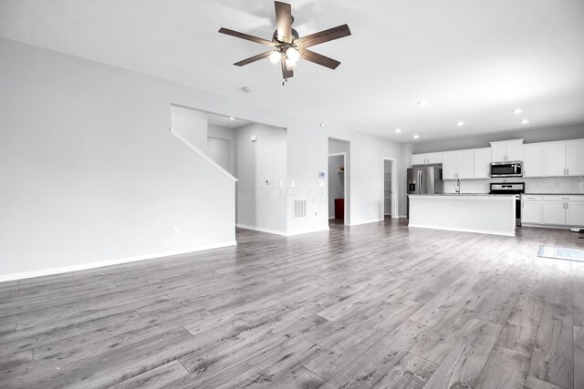 294 Shady Hollow Dr, Commercial Point, OH 43116 - unfurnished living room with recessed lighting, ceiling fan, baseboards, light wood-style flooring, and a sink