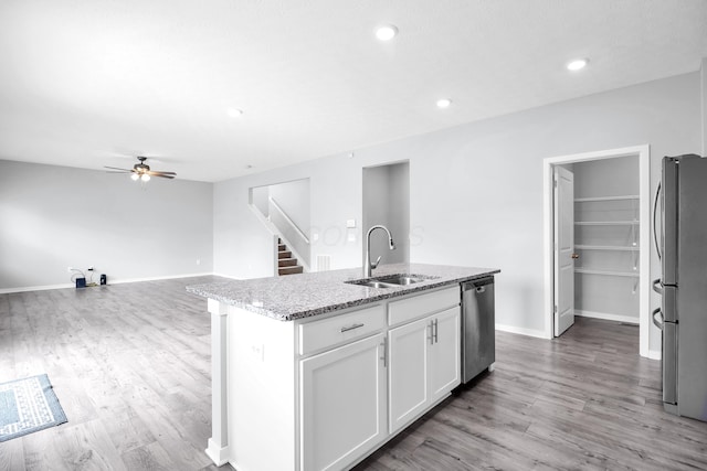 294 Shady Hollow Dr, Commercial Point, OH 43116 - kitchen with a sink, stainless steel appliances, light stone counters, white cabinets, and light wood finished floors