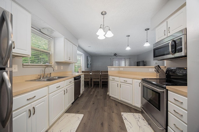 1427 Trabue Woods Blvd, Columbus, OH 43228 - kitchen with stainless steel appliances, a sink, white cabinets, light countertops, and a textured ceiling