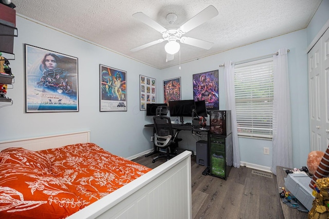 1427 Trabue Woods Blvd, Columbus, OH 43228 - bedroom featuring wood finished floors, a textured ceiling, ceiling fan, baseboards, and a closet