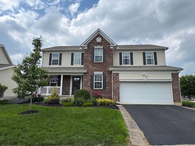 118 Firestone Dr, Delaware, OH 43015 - view of front facade featuring asphalt driveway, a garage, stucco siding, and a front lawn