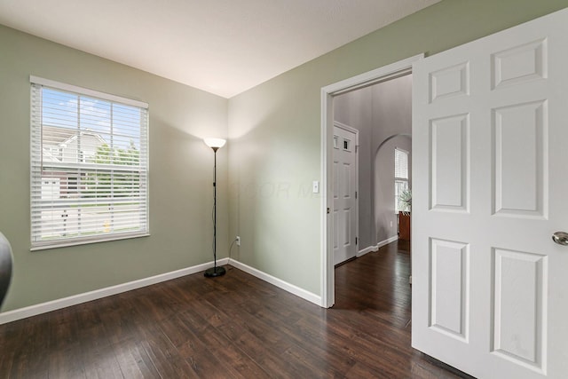 118 Firestone Dr, Delaware, OH 43015 - empty room with baseboards, plenty of natural light, dark wood-style floors, and arched walkways