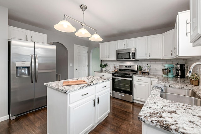 118 Firestone Dr, Delaware, OH 43015 - kitchen with appliances with stainless steel finishes, a sink, arched walkways, tasteful backsplash, and dark wood finished floors