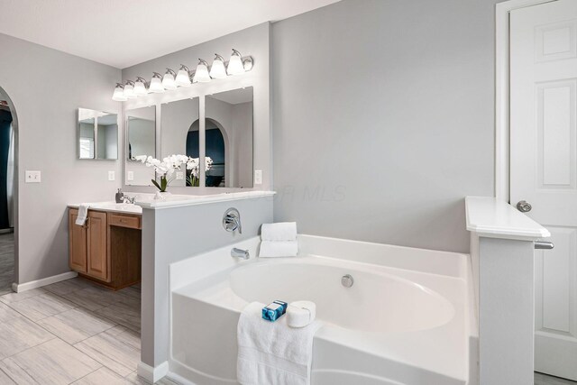 118 Firestone Dr, Delaware, OH 43015 - bathroom featuring a garden tub, vanity, and baseboards
