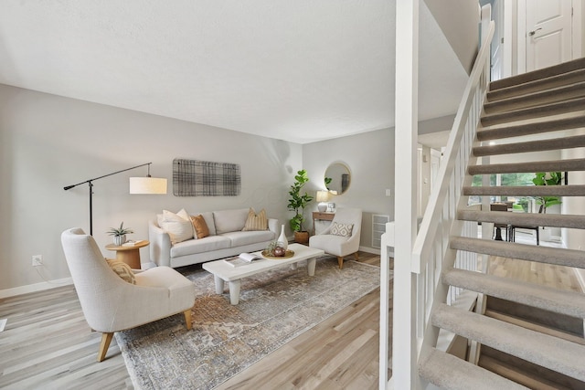 894 Noddymill Ln E Unit 28E, Columbus, OH 43085 - living room with stairway, light wood-style floors, and baseboards