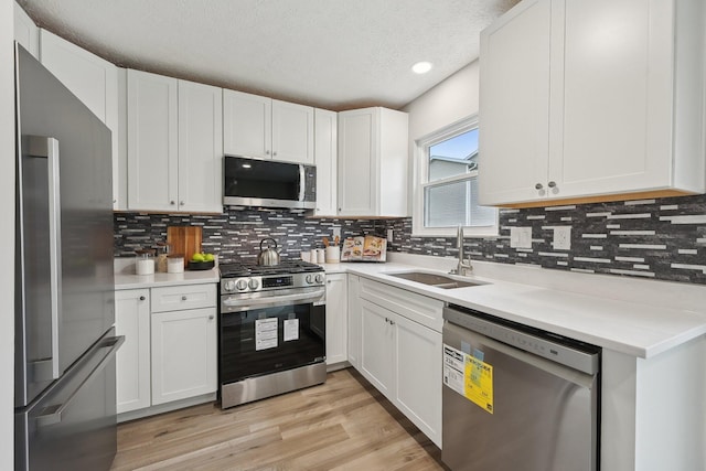 894 Noddymill Ln E Unit 28E, Columbus, OH 43085 - kitchen with appliances with stainless steel finishes, a sink, decorative backsplash, white cabinets, and light countertops