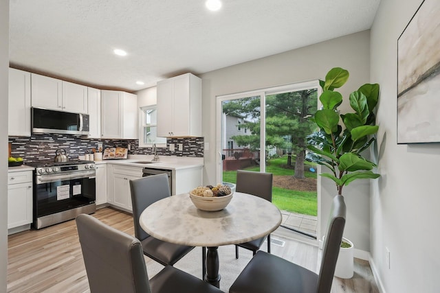 894 Noddymill Ln E Unit 28E, Columbus, OH 43085 - kitchen with stainless steel appliances, backsplash, light countertops, a sink, and white cabinets