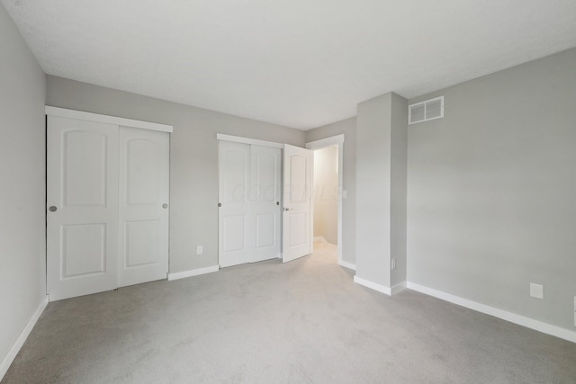 894 Noddymill Ln E Unit 28E, Columbus, OH 43085 - unfurnished bedroom featuring light colored carpet, baseboards, and multiple closets