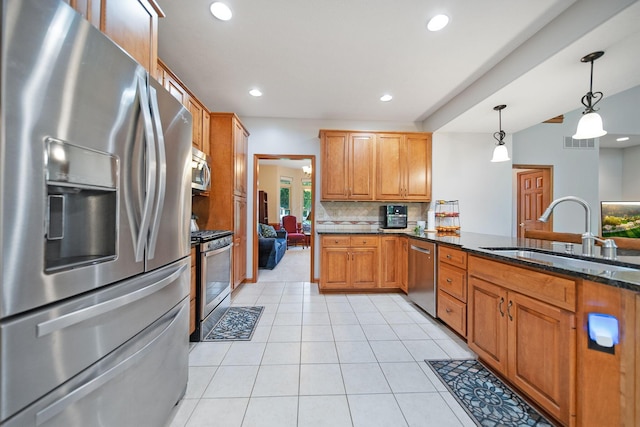 6962 Whitetail Ln, Westerville, OH 43082 - kitchen with appliances with stainless steel finishes, a sink, dark stone countertops, backsplash, and light tile patterned floors