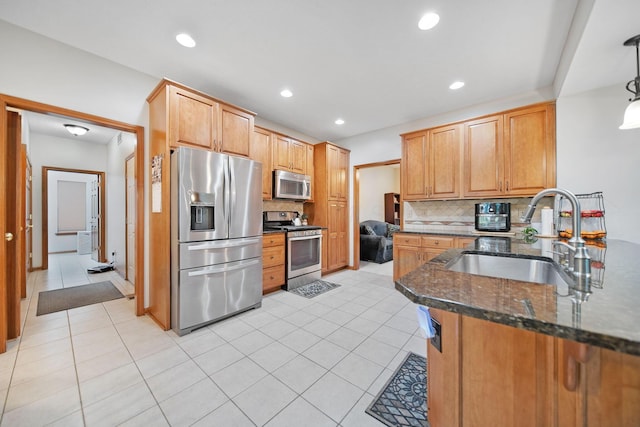 6962 Whitetail Ln, Westerville, OH 43082 - kitchen with appliances with stainless steel finishes, a sink, decorative backsplash, dark stone counters, and light tile patterned floors
