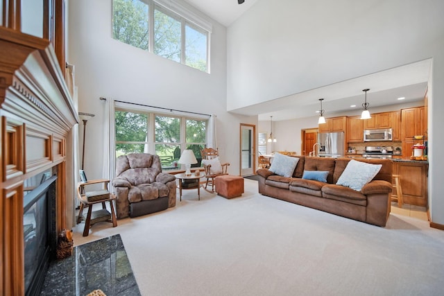 6962 Whitetail Ln, Westerville, OH 43082 - living area with light carpet, a high ceiling, a high end fireplace, healthy amount of natural light, and recessed lighting