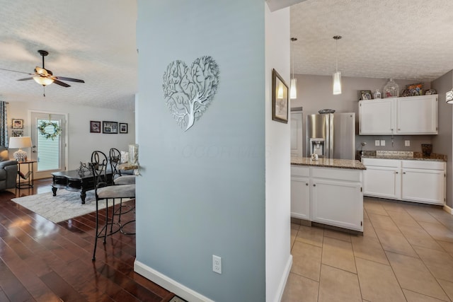 5718 Brook Hollow Dr, Hilliard, OH 43026 - kitchen with stainless steel refrigerator with ice dispenser, a textured ceiling, ceiling fan, white cabinetry, and stone countertops
