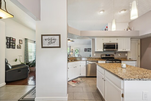 5718 Brook Hollow Dr, Hilliard, OH 43026 - kitchen featuring stainless steel appliances, light tile patterned floors, a sink, white cabinetry, and a textured ceiling