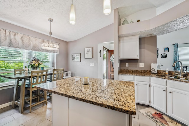 5718 Brook Hollow Dr, Hilliard, OH 43026 - kitchen featuring a sink, lofted ceiling, plenty of natural light, white cabinets, and a textured ceiling