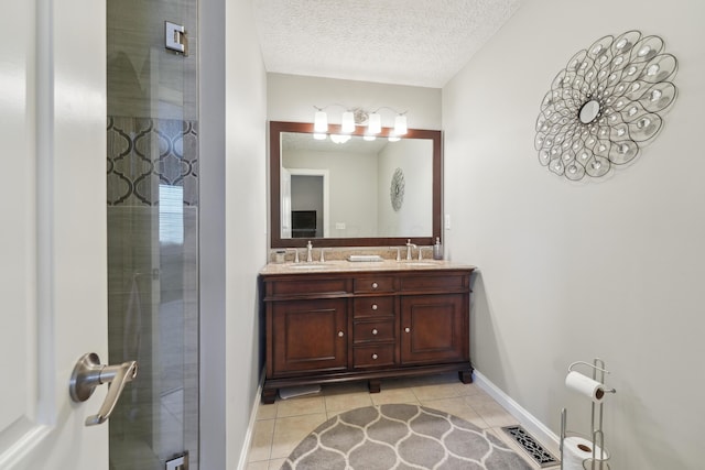 5718 Brook Hollow Dr, Hilliard, OH 43026 - full bath with tile patterned flooring, double vanity, baseboards, a textured ceiling, and an enclosed shower