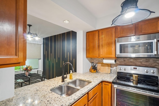 1450 Cliff Ct Unit 25, Columbus, OH 43204 - kitchen with stainless steel appliances, a sink, light stone counters, backsplash, and brown cabinets