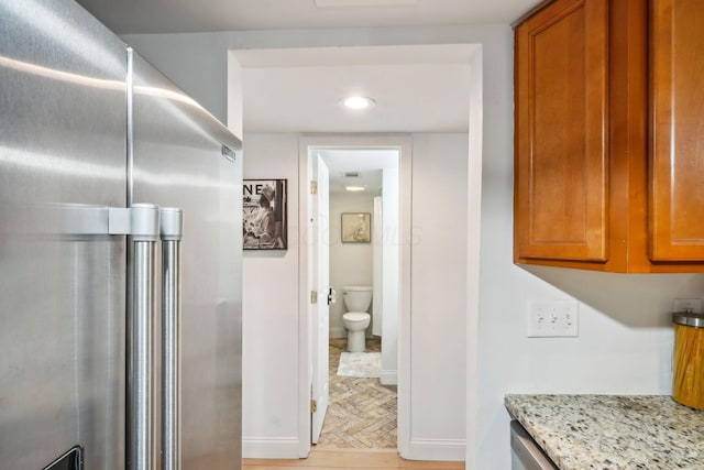 1450 Cliff Ct Unit 25, Columbus, OH 43204 - kitchen with freestanding refrigerator, light stone countertops, baseboards, brown cabinets, and recessed lighting