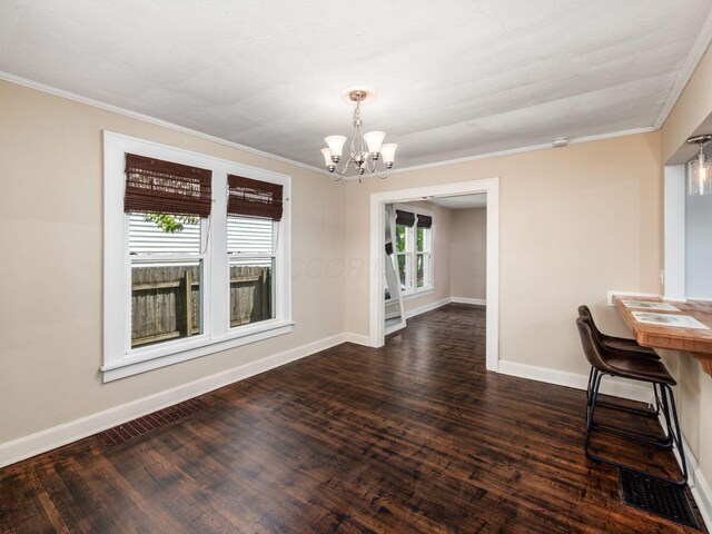 34 Columbus Ave, Delaware, OH 43015 - unfurnished dining area featuring a chandelier, dark wood-style flooring, baseboards, and ornamental molding