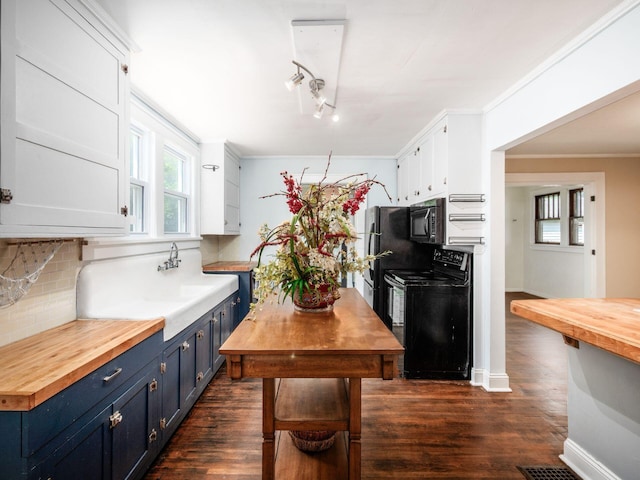 34 Columbus Ave, Delaware, OH 43015 - kitchen featuring black appliances, butcher block countertops, blue cabinets, tasteful backsplash, and white cabinets
