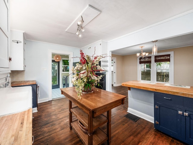 34 Columbus Ave, Delaware, OH 43015 - kitchen featuring butcher block counters, blue cabinets, baseboards, a chandelier, and white cabinetry