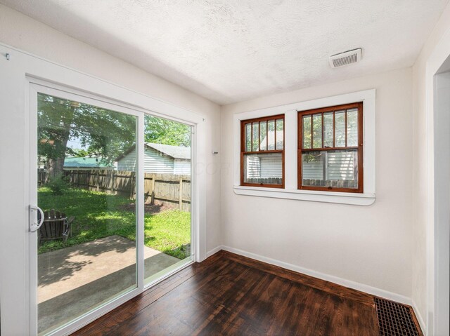34 Columbus Ave, Delaware, OH 43015 - doorway to outside featuring baseboards, dark wood-style flooring, and a textured ceiling