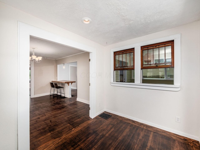 34 Columbus Ave, Delaware, OH 43015 - unfurnished room with baseboards, dark wood finished floors, a chandelier, and a textured ceiling