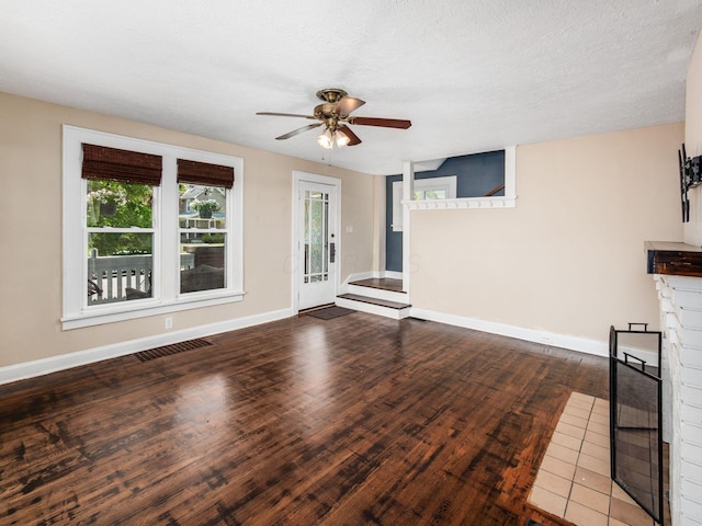 34 Columbus Ave, Delaware, OH 43015 - unfurnished living room featuring ceiling fan, a brick fireplace, wood finished floors, and baseboards