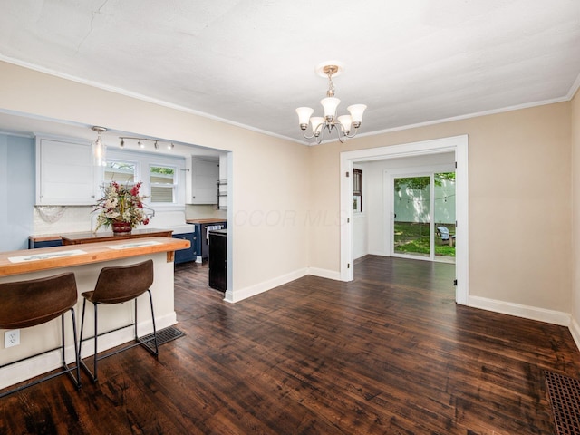 34 Columbus Ave, Delaware, OH 43015 - dining space with a chandelier, healthy amount of natural light, dark wood-style floors, baseboards, and ornamental molding