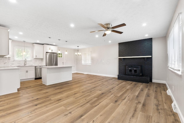 3998 Scioto Darby Creek Rd, Hilliard, OH 43026 - unfurnished living room featuring a ceiling fan, a sink, light wood-style floors, recessed lighting, and a fireplace
