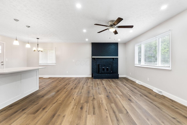 3998 Scioto Darby Creek Rd, Hilliard, OH 43026 - unfurnished living room with ceiling fan, a textured ceiling, recessed lighting, wood finished floors, and a chandelier